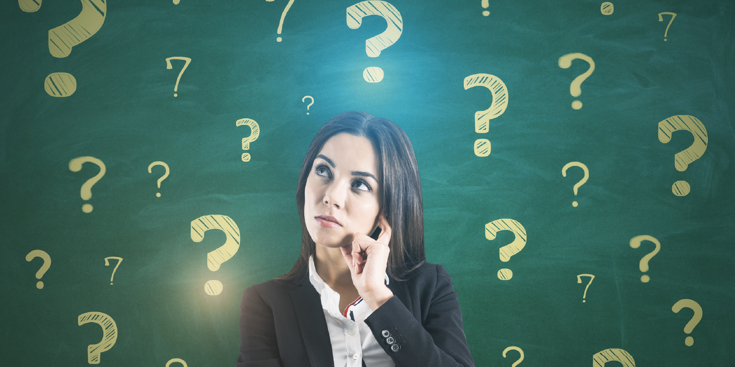 Thoughtful woman surrounded by question marks on a chalkboard