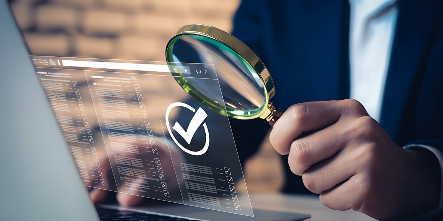 Magnifying glass checking a data table with a verified tick on a laptop screen