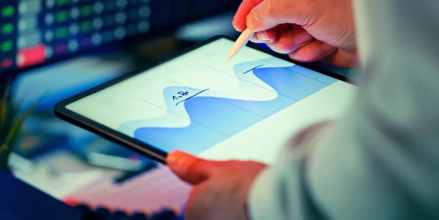 Person sketching a trend line on a tablet