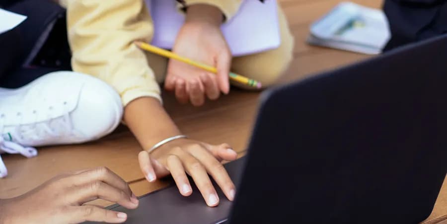 Hands typing on a laptop at a table during a usage study